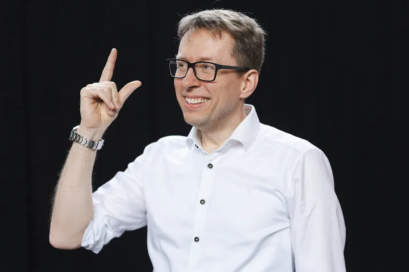 Dr. Daniel Schwenger smiling and pointing upwards